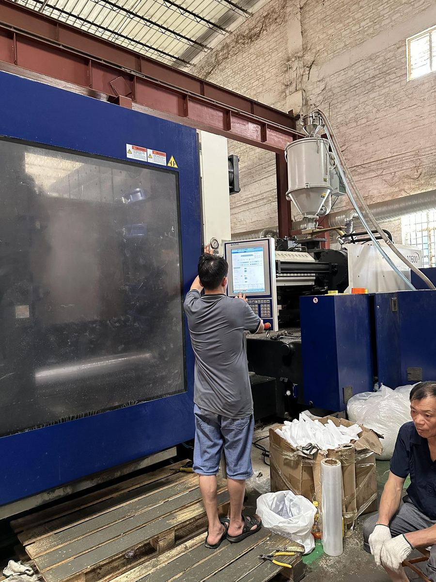 Injection moulding machine producing chair components, operated by a technician